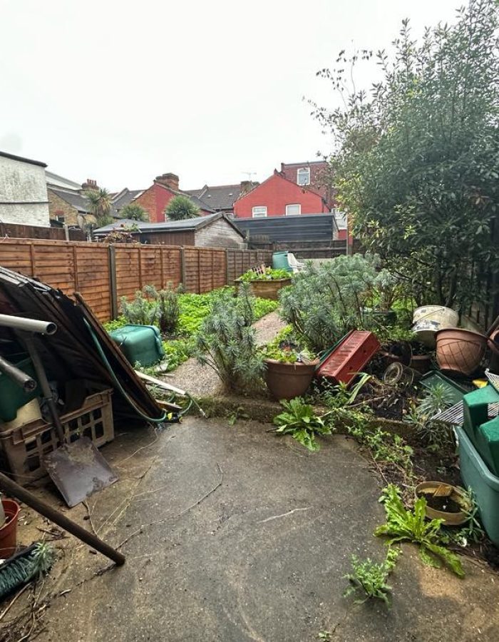 Garden clearance showing lots of outdoor materials before photo