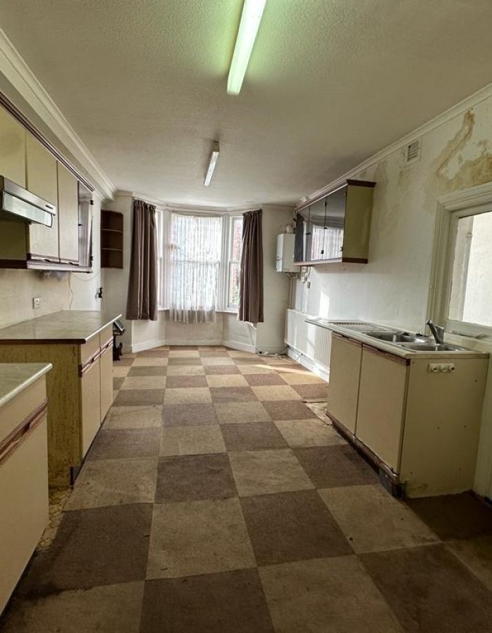 House clearance of a kitchen with tiled flooring and damp walls after photo