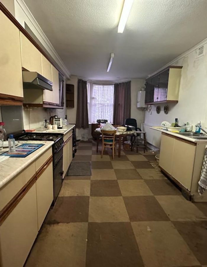 House clearance of a kitchen with tiled flooring and damp walls before photo